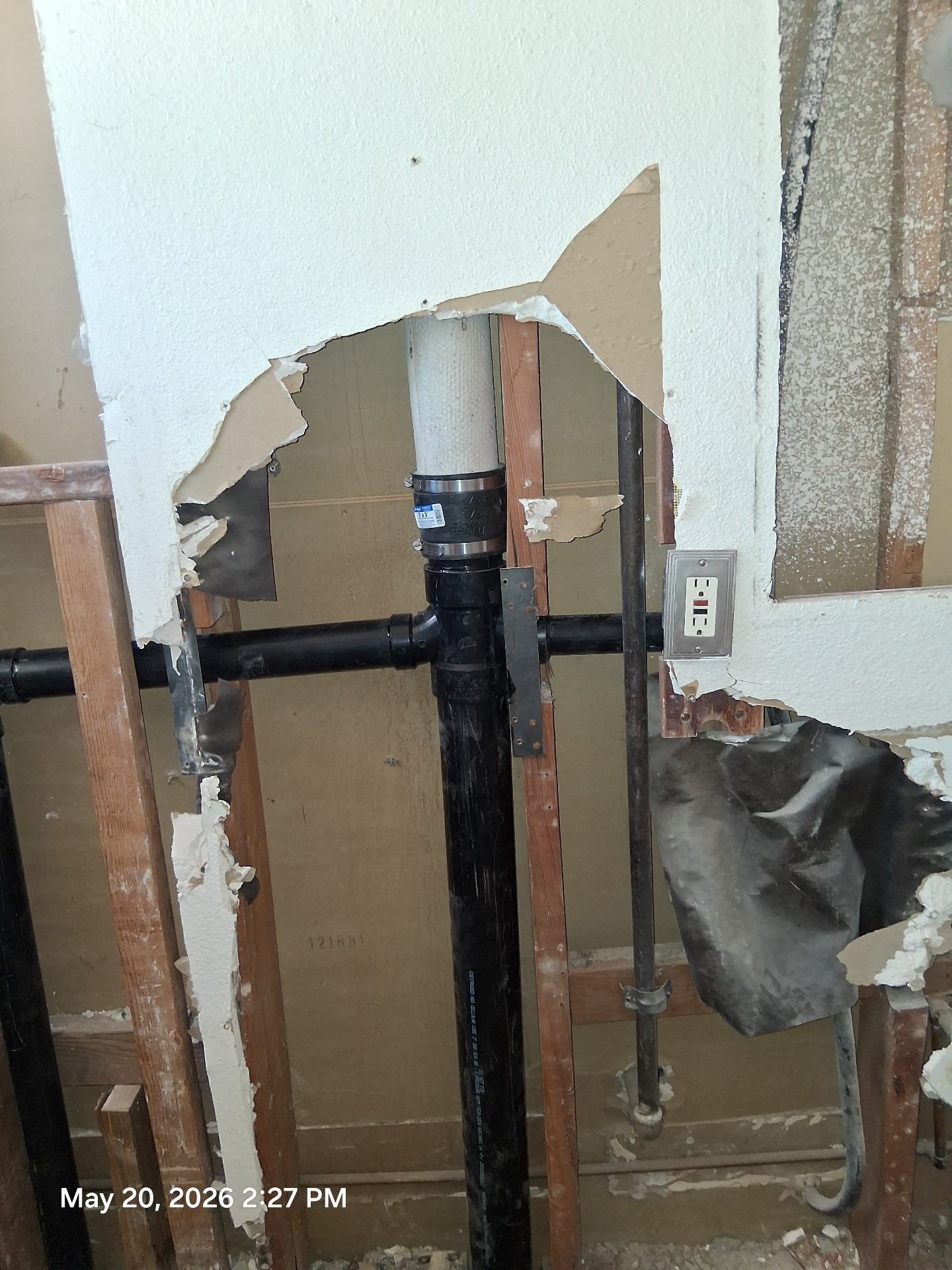 Black ABS drain stack replacement inside open wall framing